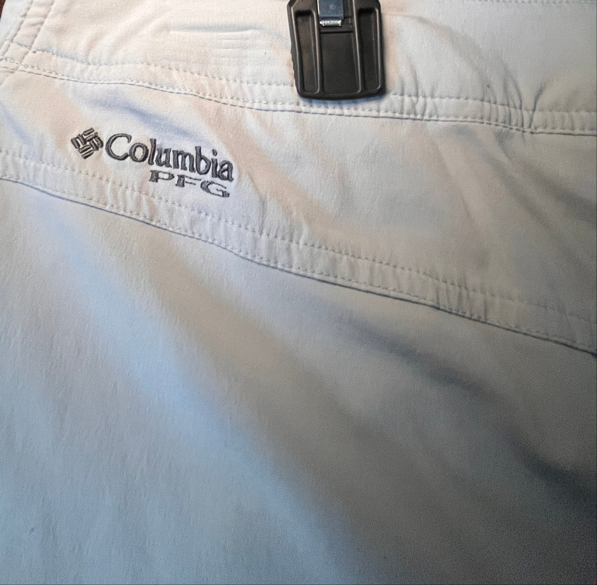Columbia Omni-Shield logo detail on sage-green shorts