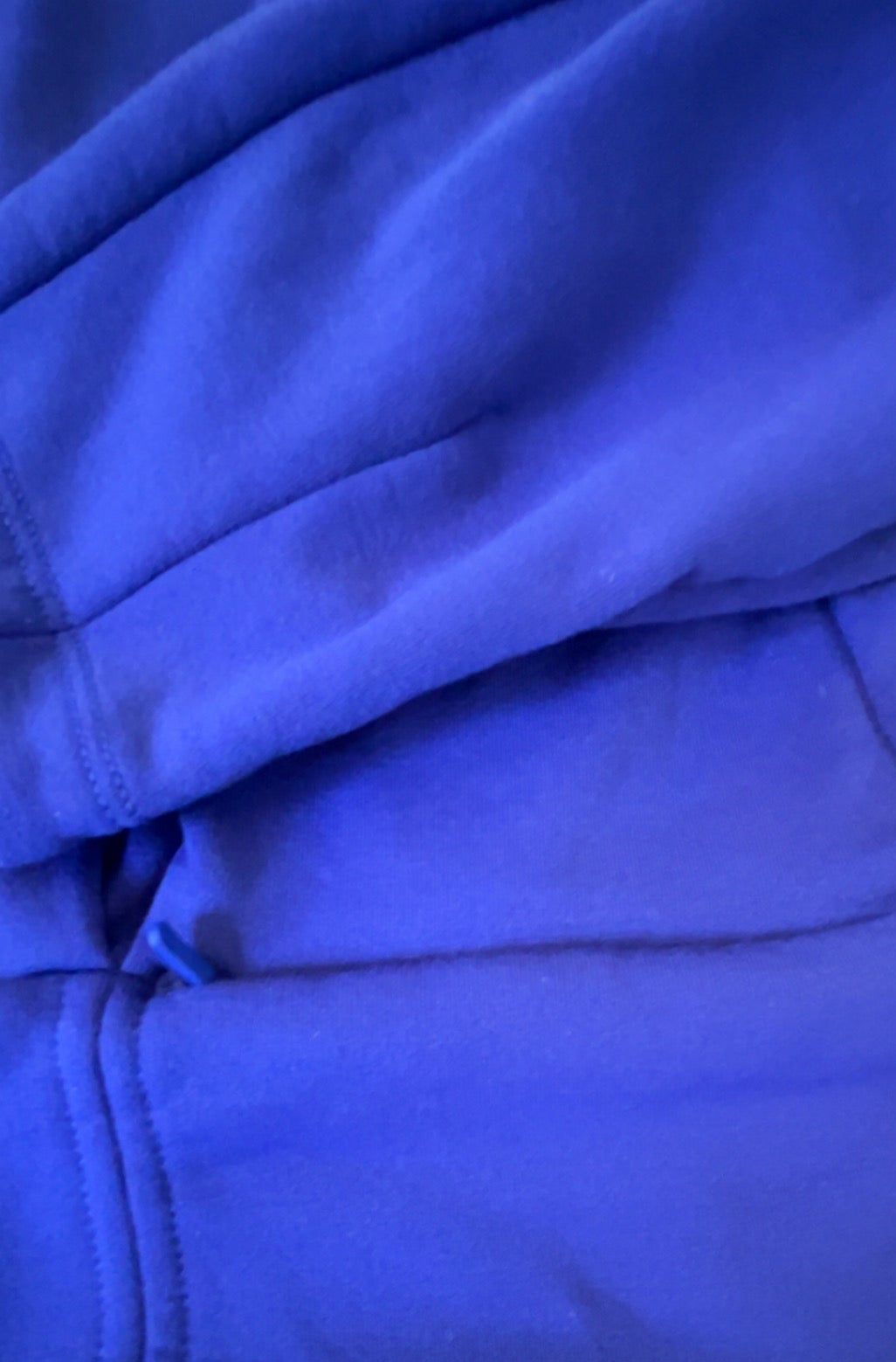 Close-up of waist zipper pocket on purple Athleta pullover